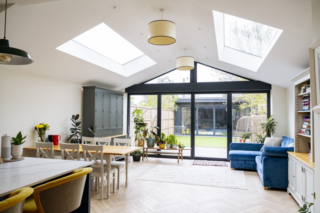 Interior of open plan living space in modern home extension with large patio doors to garden